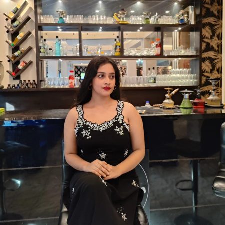 A Woman Sitting in Black Dress in Cafe
